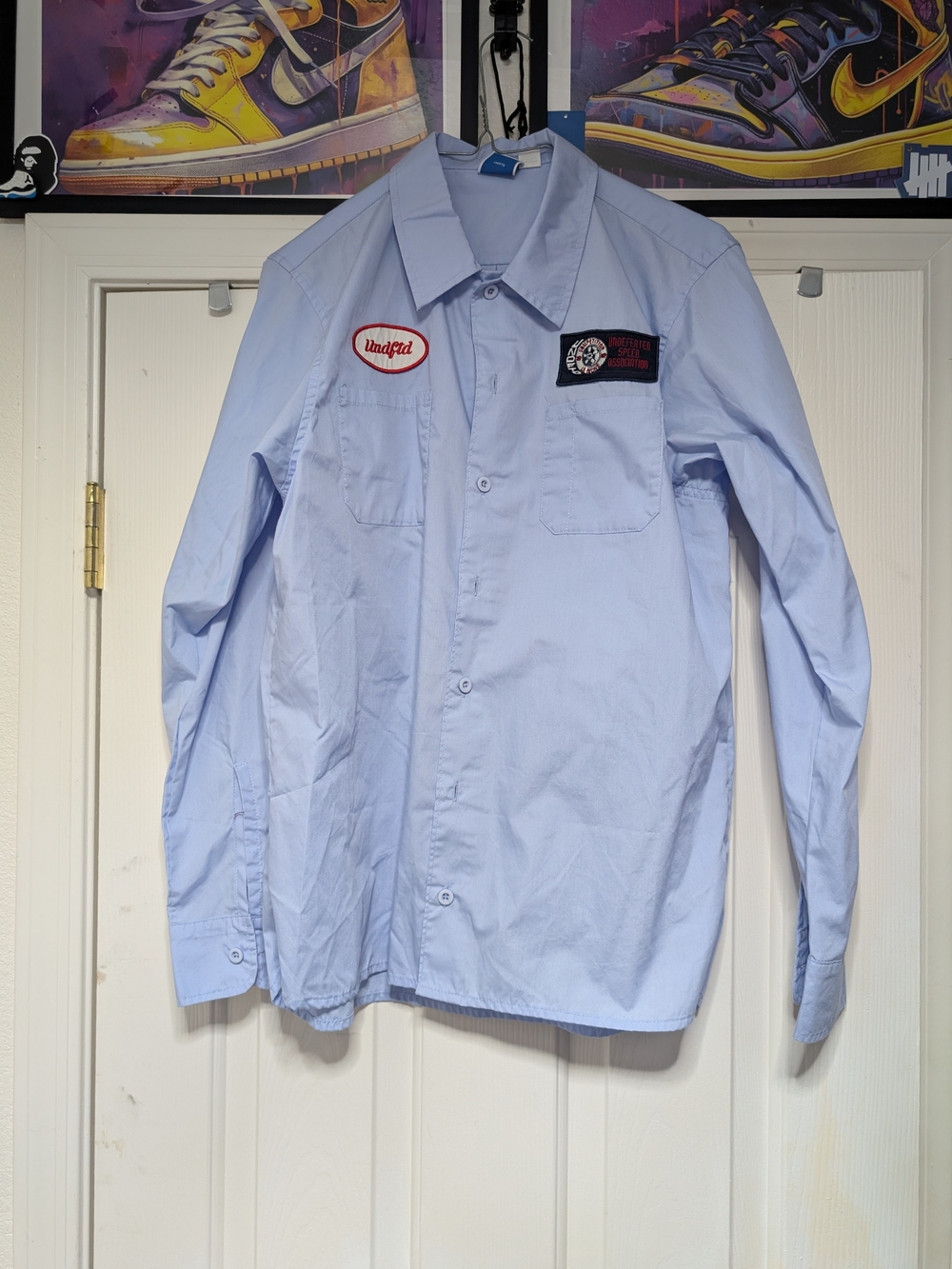 Undefeated Light Blue Long-Sleeve Shirt with Patch Logos.